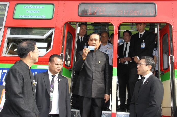 Prime Minister Prayuth Chan-ocha demos use of a welfare card to ride a Bangkok bus Tuesday at the Government House.