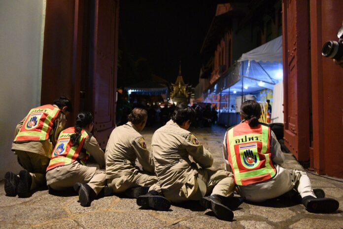 Five rescue workers, seen here prostrating before the Grand Palace’s gate, were the final mourners allowed entry to pay respect to His Majesty the Late King in the early hours of Friday morning