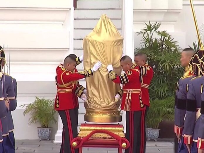 A cover is taken off the royal urn Thursday at Sanam Luang.