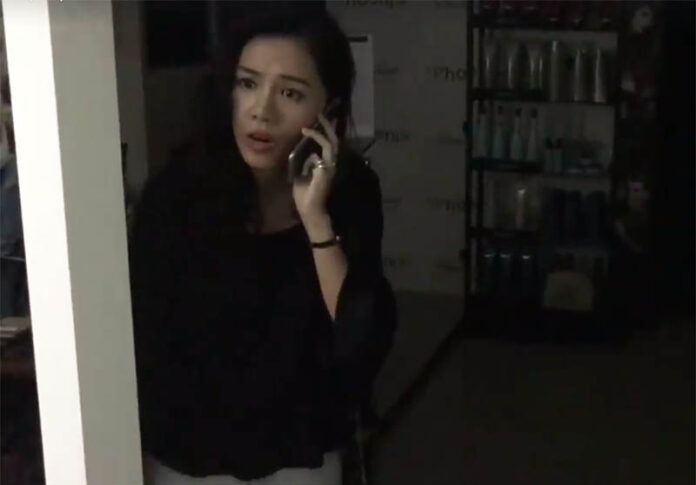 A Taiwanese woman makes a phone call in the darkened hair salon where she had a dispute with the owner Saturday at Phoenix Siam Salon.