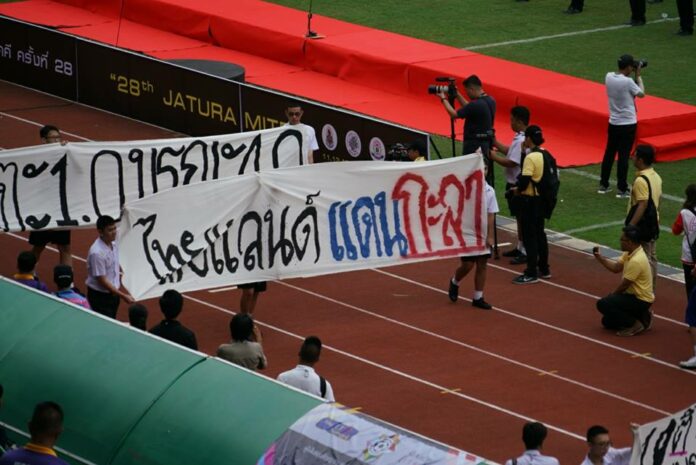 Suan Kularb students march with a banner reading ‘Thailand, Land of the Coconut Shell’ on Saturday at Bangkok’s National Stadium. Photo: Troll Students of Suan Kularb / Facebook