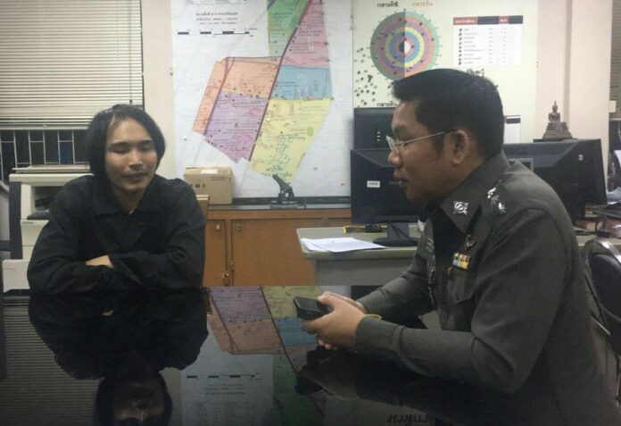 A policeman questions Peerapol Yodcharoen, at left, Thursday at Bang Sue Police Station in Bangkok.