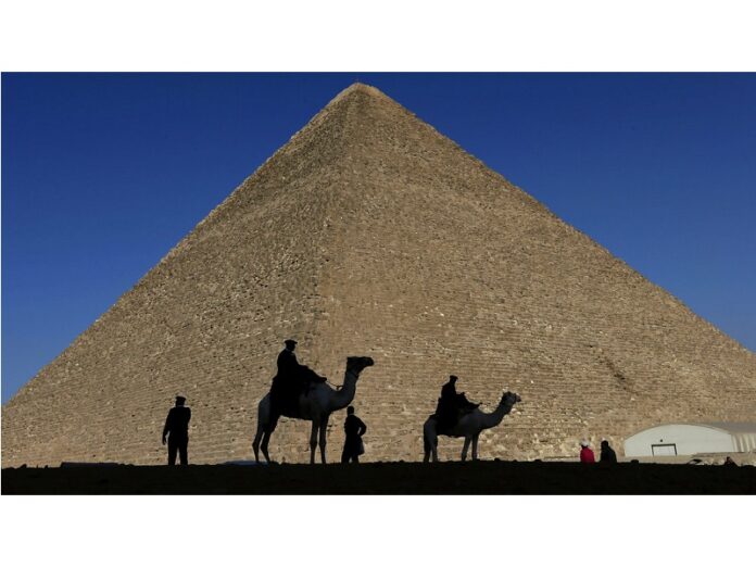 Policemen are silhouetted in 2012 against the Great Pyramid in Giza, Egypt. Photo: Hassan Ammar / Associated Press