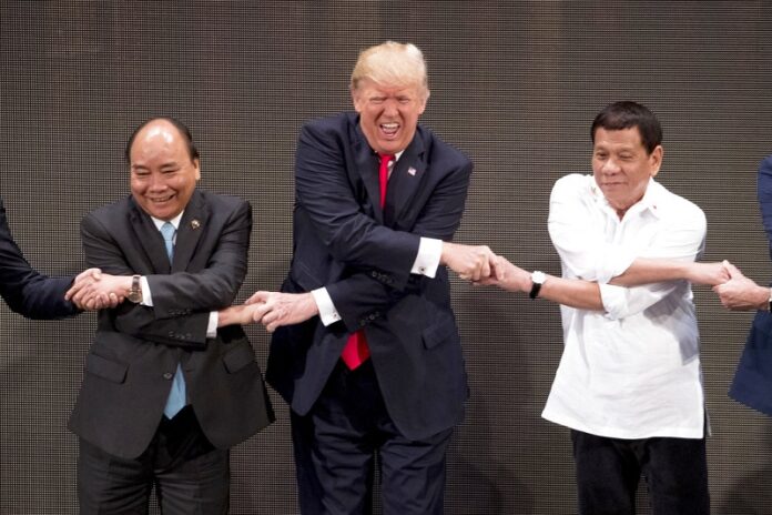 U.S. President Donald Trump, center, reacts as he does the