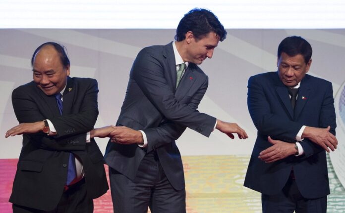 Canadian Prime Minister Justin Trudeau, center, shakes hands with Vietnamese Prime Minister Nguyen Xuan Phuc, left, and Philippine President Rodrigo Duterte during a photo session of the ASEAN-Canada 40th Commemorative session Tuesday in Manila, Philippines. Photo: Adrian Wyld / Associated Press