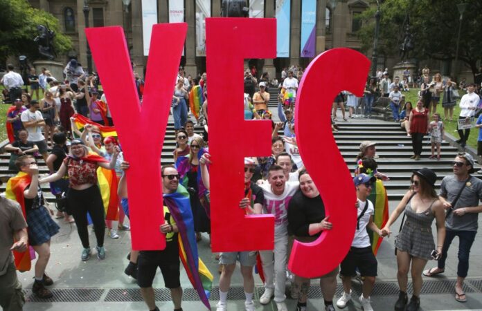 People celebrate after the announcement of the same-sex marriage postal survey result in front of the State Library of Victoria in Melbourne, Australia, Wednesday, Nov. 15, 2017. Australians supported gay marriage in a postal survey that ensures Parliament will consider legalizing same-sex weddings this year. Photo: David Crosling / AAP Image via AP