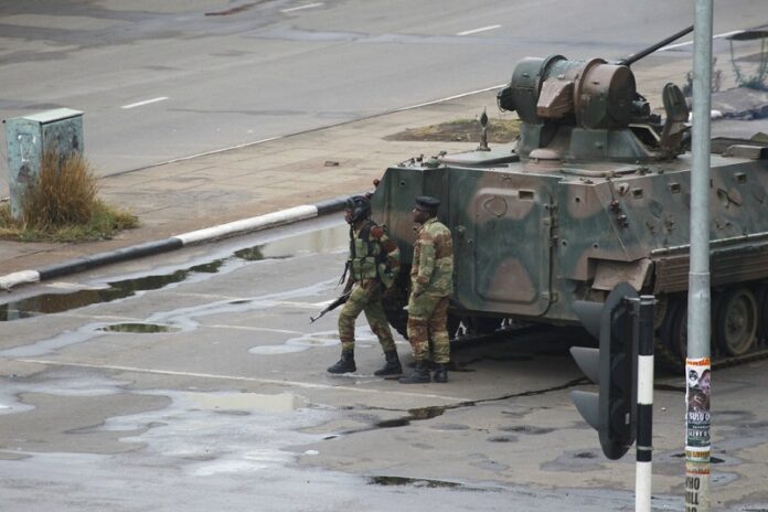A military tank is seen with armed soldiers on the road leading to President Robert Mugabe's office on Wednesday in Harare, Zimbabwe. Photo: Tsvangirayi Mukwazhi / Associated Press
