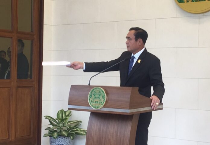 Junta chairman Prayuth Chan-ocha hands his six questions to reporters Thursday