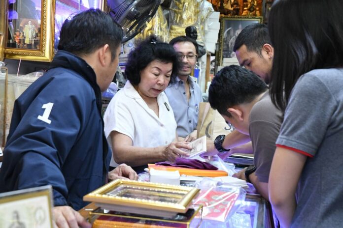 Tassanee Horcharankul talks to police officers Wednesday at her shop in Bangkok.