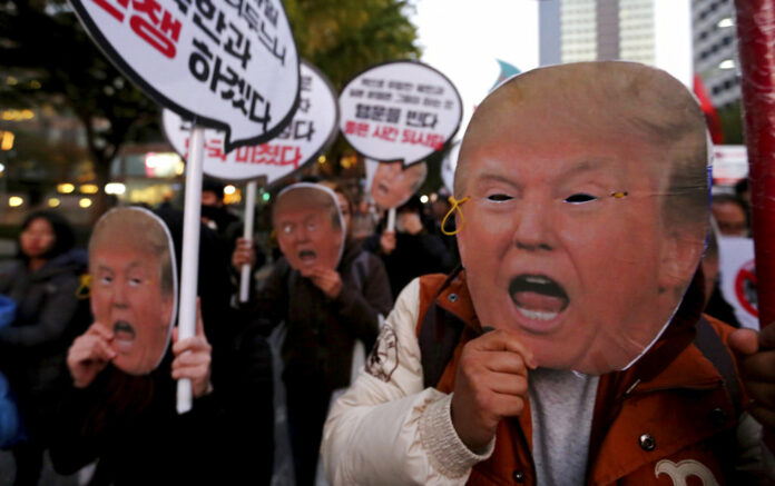 Protesters wearing masks of U.S. President Donald Trump march toward the US Embassy at a rally Saturday to oppose his planned visit in Seoul, South Korea. The signs read 'Stop the War.' Photo: Ahn Young-joon / Associated Press Protesters wearing masks of U.S. President Donald Trump march toward the US Embassy at a rally Saturday to oppose his planned visit in Seoul, South Korea. The signs read 'Stop the War.' Photo: Ahn Young-joon / Associated Press