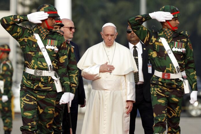 Pope Francis reviews a honor guard Thursday as he arrives at Dhaka's international airport, Bangladesh. Photo: Andrew Medichini / Associated Press