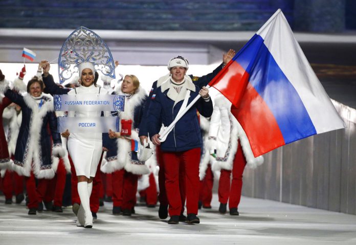 In this 2014 file photo Alexander Zubkov of Russia carries the national flag as he leads the team during the opening ceremony of the 2014 Winter Olympics in Sochi, Russia. Photo: Mark Humphrey / Associated Press