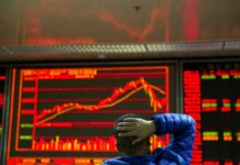 Asian Shares Mostly Fall on Weak Japan Data, US-China Trade An investor looks at the Chinese market index in 2017 at a brokerage in Beijing, China. Photo: Ng Han Guan / Associated Press