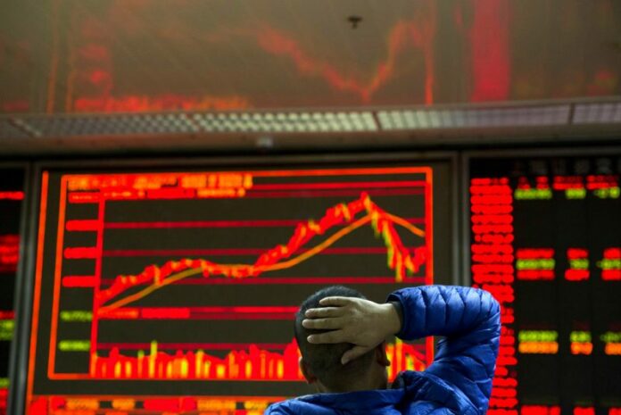An investor looks at the Chinese market index in 2017 at a brokerage in Beijing, China. Photo: Ng Han Guan / Associated Press