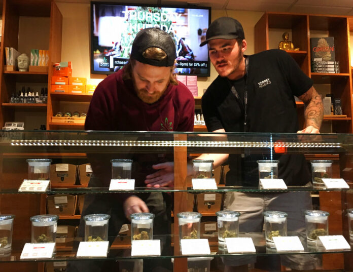 Torrey Holistics employees, Matt Sullivan, left, and Taron McElroy, arrange jars of cannabis in San Diego, Calif., Thursday, Dec. 14, 2017. On Thursday, California issued its first batch of business licenses for the state's upcoming legal marijuana market, setting the stage for sales to begin to adults in January. The first license for recreational retail sales went to Torrey Holistics in San Diego. Photo: Julie Watson / Associated Press