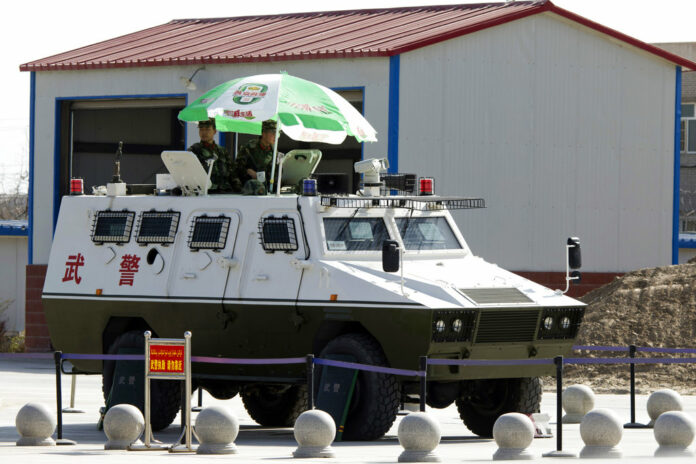 Paramilitary policemen in an armored vehicle on duty Nov. 3 at the airport in Hotan in western China's Xinjiang region. Photo: Ng Han Guan / Associated Press