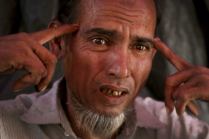 In this Tuesday, Nov. 28, 2017, photo, Shafir Rahman, 50, describes how he watched a soldier hammering a four-inch nail into the side of a man's head with a rifle butt during an interview with The Associated Press in his tent in Jamtoli refugee camp in Bangladesh. Photo: Wong Maye-E / Associated Press