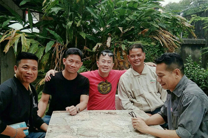 Ford Red Path Anurak Jeantawanich, in red, with officers who visited his home Tuesday morning. Photo: Anurak Jeantawanich / Facebook