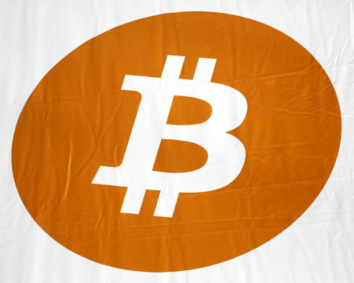 A bitcoin logo is displayed at a 2014 Inside Bitcoins conference and trade show in New York. Photo: Mark Lennihan / AP