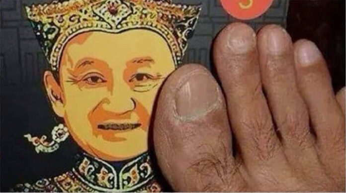 An image of a foot on the face of fugitive former Prime Minister Thaksin Shinawatra in a tweet accusing the author of this column of being on his payroll by @JOUI7SyNmDeFxi0.
