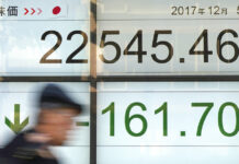 Asian Stocks Mixed Ahead of Next Round of US-China Talks A man walks past an electronic stock board showing Japan's Nikkei 225 index at a securities firm in Tokyo on Dec. 5, 2017. Photo: Eugene Hoshiko / Associated Press