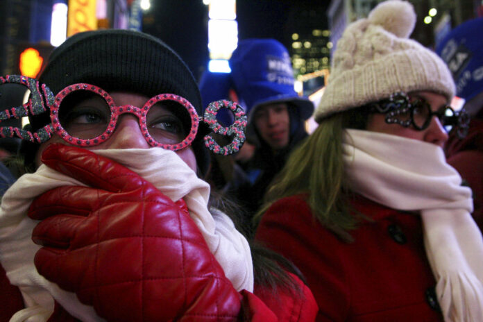 NYE Allison Smith, at left, tries to keep warm as she and others take part in the New Year's Eve festivities in 2008 om New York's Times Square. Photo: Tina Fineberg / Associated Press