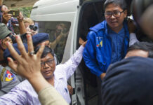 Myanmar Court Keeps 2 Reuters Reporters Jailed Reuters journalist Thet Oo Maung Maung, aka Wa Lone, exits a police van while his wife Pan Ei Mon waves upon his arrival at the township court for an appearance Wednesday outside Yangon. Photo: Thein Zaw / Associated Press