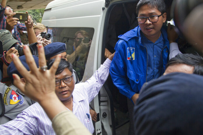 Reuters journalist Thet Oo Maung Maung, aka Wa Lone, exits a police van while his wife Pan Ei Mon waves upon his arrival at the township court for an appearance Wednesday outside Yangon. Photo: Thein Zaw / Associated Press