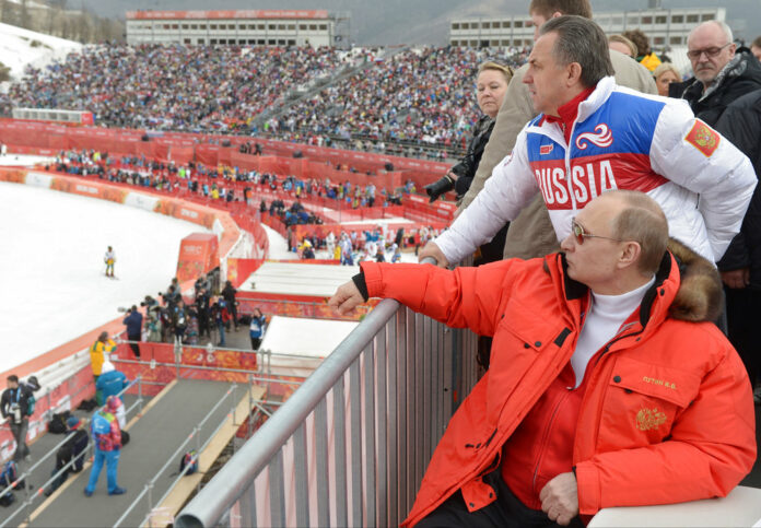 Russian President Vladimir Putin, foreground, watches downhill ski competition at the 2014 Winter Paralympics in the Roza Khutor mountain district of Sochi, Russia, as Russia's sports minister Vitaly Mutko stands behind. Photo: RIA-Novosti, Alexei Nikolsky, Presidential Press Service