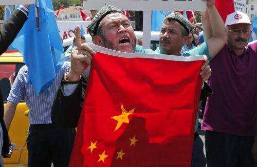 Uighurs living in Turkey and Turkish supporters chant slogans on July 5, 2015, as they hold a Chinese flag before burning it during a protest near China's consulate in Istanbul. Photo: Lefteris Pitarakis / Associated Press