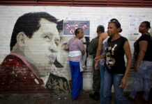 US Withdrawing Last of Its Embassy Personnel From Venezuela People search for their names on voter lists for mayoral elections by a mural of Venezuela's late President Hugo Chavez at a school serving as a polling station in 2017 in Caracas, Venezuela. Photo: Ariana Cubillos / Associated Press
