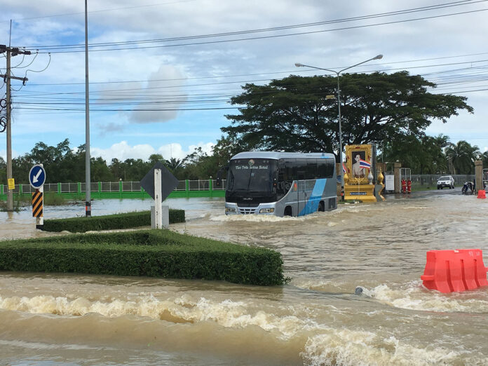 A tour bus attempts to drive Thursday through the flooded entrance of Nakhon Si Thammarat Airport.