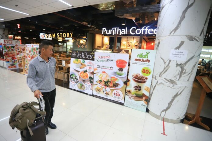 A tourist Wednesday outside the Punthai Coffee shop in Don Mueang International Airport.
