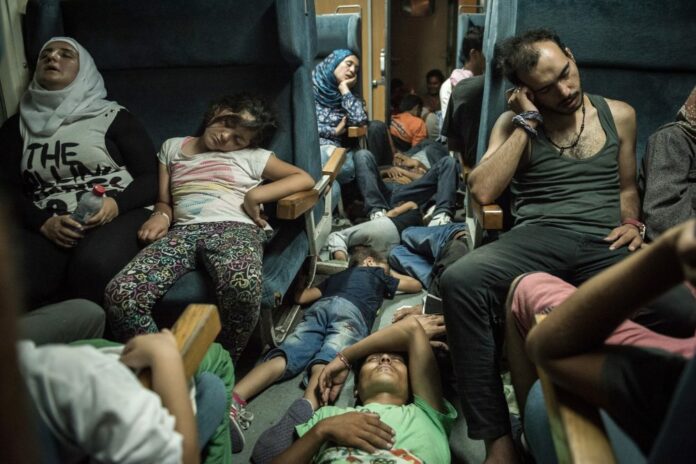 Syrian refugees sleep inside a train as they travel across Macedonia to Serbia. Photo: Sergey Ponomarev via Exodus-deja vu