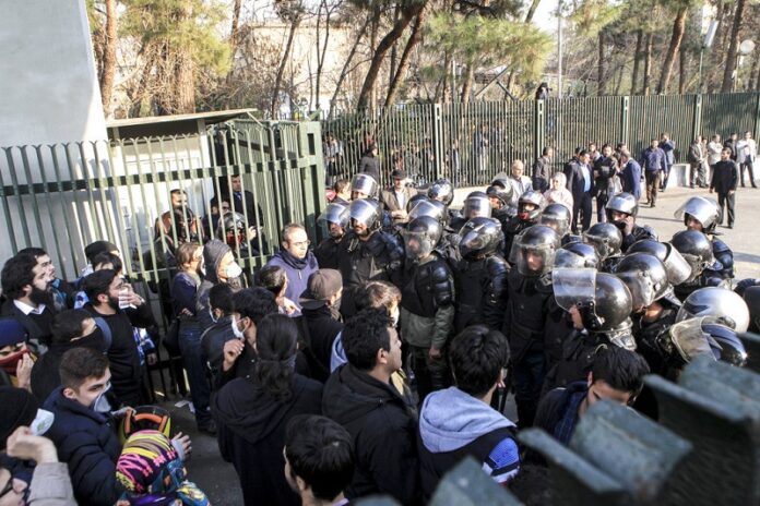 Anti-riot Iranian police prevent university students to join other protesters over Iran weak economy, Saturday in Tehran, Iran. Photo: Associated Press