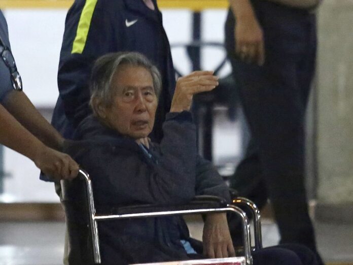 Former President Alberto Fujimori is wheeled out the hospital he was interned, in, Thursday in Lima, Peru. Photo: Miguel Paredes / Associated Press