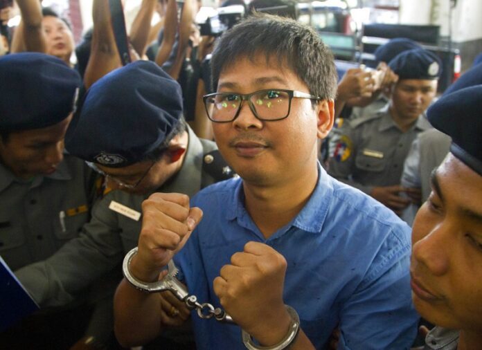 Reuters journalist Thet Oo Maung Maung, known as Wa Lone, is escorted by police upon arrival at court Wednesday, Jan. 10, 2018, outside Yangon, Myanmar. Photo: Thein Zaw / Associated Press