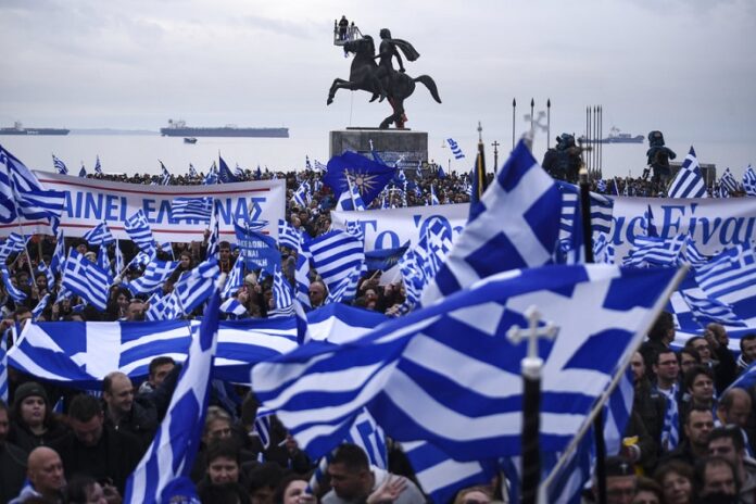 Greek protesters wave flags and banners Sunday during a rally against the use of the term