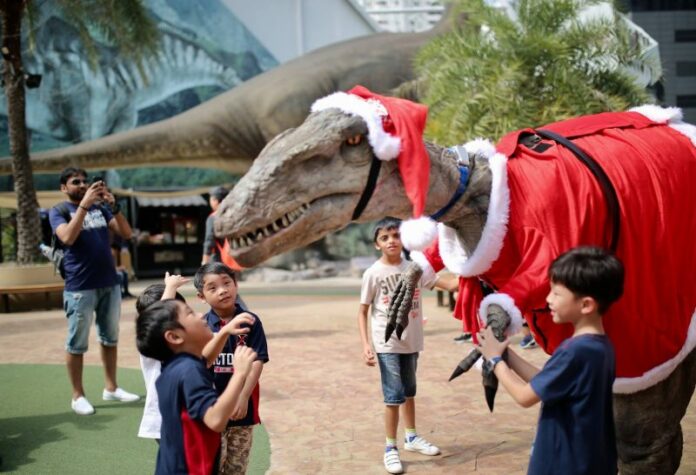 Kids on Dec. 24 play with a dinosaur at Dinosaur Planet. Photo: Dinosaur Planet / Facebook