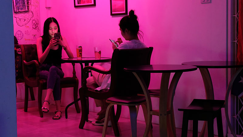 Customers browse their phones at Bad Taste Cafe.