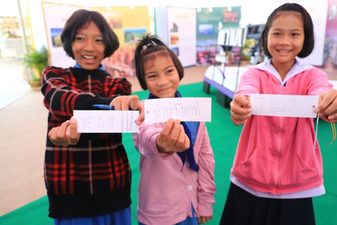 Children in Bueng Kan province show the messages they wrote for their hometown Thursday at the annual Red Cross and Rubber Day event.