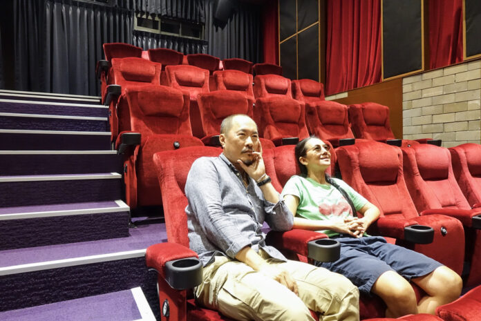 Manit Sriwanichpoom and Ing Kanjanavanit sit inside Cinema Oasis.