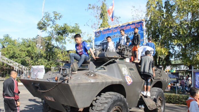 Children climb on an army tank Saturday at the Office of Disaster Prevention and Mitigation in Udon Thani.