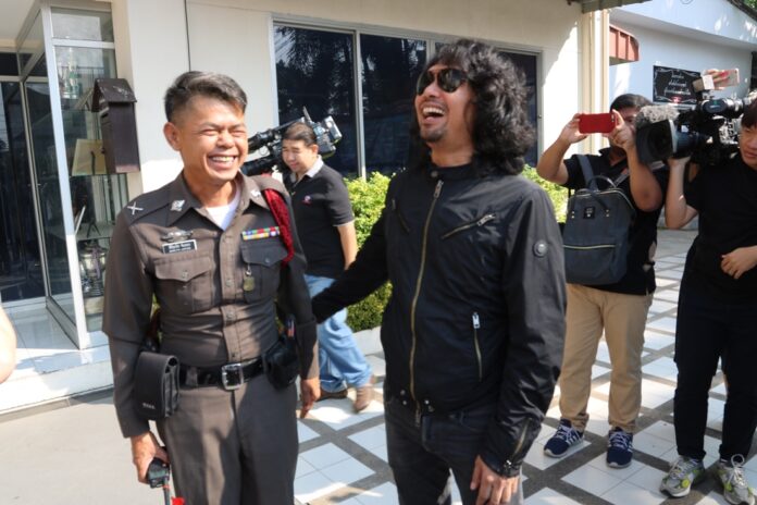 Rocker Sek Loso, who just today challenged results of a recent drug test, enjoys a moment of levity with an officer of the law.