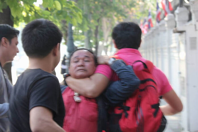 Undercover police drag Rittikrai Chaiwannasan away Friday moments after he assaulted pro-democracy activist Ekachai Hongkanwan.