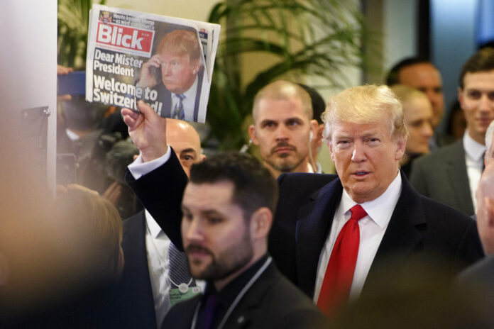 US President Donald Trump holds up Swiss newspaper 'Blick' as he arrives at the Congress Center on the last day of the annual meeting of the World Economic Forum, WEF, in Davos, Switzerland on Friday. Photo: Laurent Gillieron / Keystone