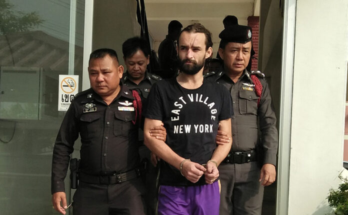 Amaury Rigaud is escorted by police Monday in Phichit province.