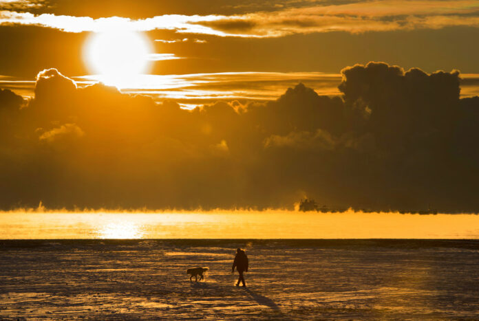 A man walks his dog across the snow-covered beach while a cargo ship sits in the steaming fog of Lake Ontario in Toronto. According to a report released on Thursday, Jan. 18, 2018, U.S. and British scientists calculate that 2017 wasn’t the hottest year on record, but close and unusually warm for no El Nino cooking the books. Photo: Frank Gunn / The Canadian Press A man walks his dog across the snow-covered beach while a cargo ship sits in the steaming fog of Lake Ontario in Toronto. According to a report released on Thursday, Jan. 18, 2018, U.S. and British scientists calculate that 2017 wasn’t the hottest year on record, but close and unusually warm for no El Nino cooking the books. Photo: Frank Gunn / The Canadian Press