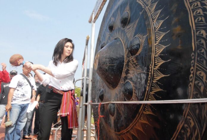 Then-candidate Yingluck Shinawatra strikes a gong on May 27, 2011, in Maha Sarakham province to signal the start of her election campaign in the Isaan region.
