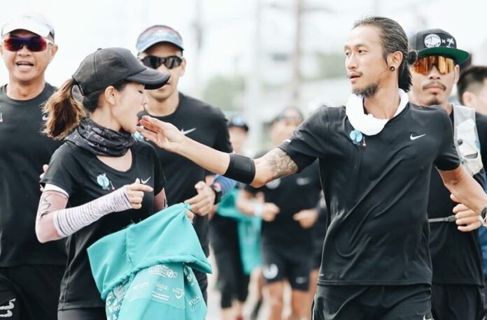 Toon Bodyslam feeds lotus seeds to Koy Ratchawin during a charity run in Prachuap Khiri Khan province on November 28